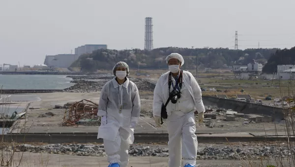 Personas en trajes de protección cerca de la planta nuclear Fukushima 2
