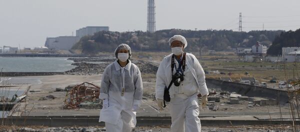 Personas en trajes de protección cerca de la planta nuclear Fukushima 2 - Sputnik Mundo