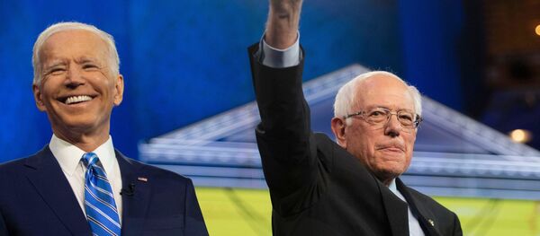 Democratic presidential primary candidates Vice President Joe Biden and Sen. Bernie Sanders greet the audience from the debate stage Thursday, June 27, 2019, at the Adrienne Arsht Center for the Performing Arts in Miami. Tcn Debate - Sputnik Mundo