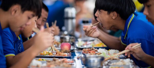 Unos jóvenes chinos comiendo Unos jóvenes chinos comiendo - Sputnik Mundo