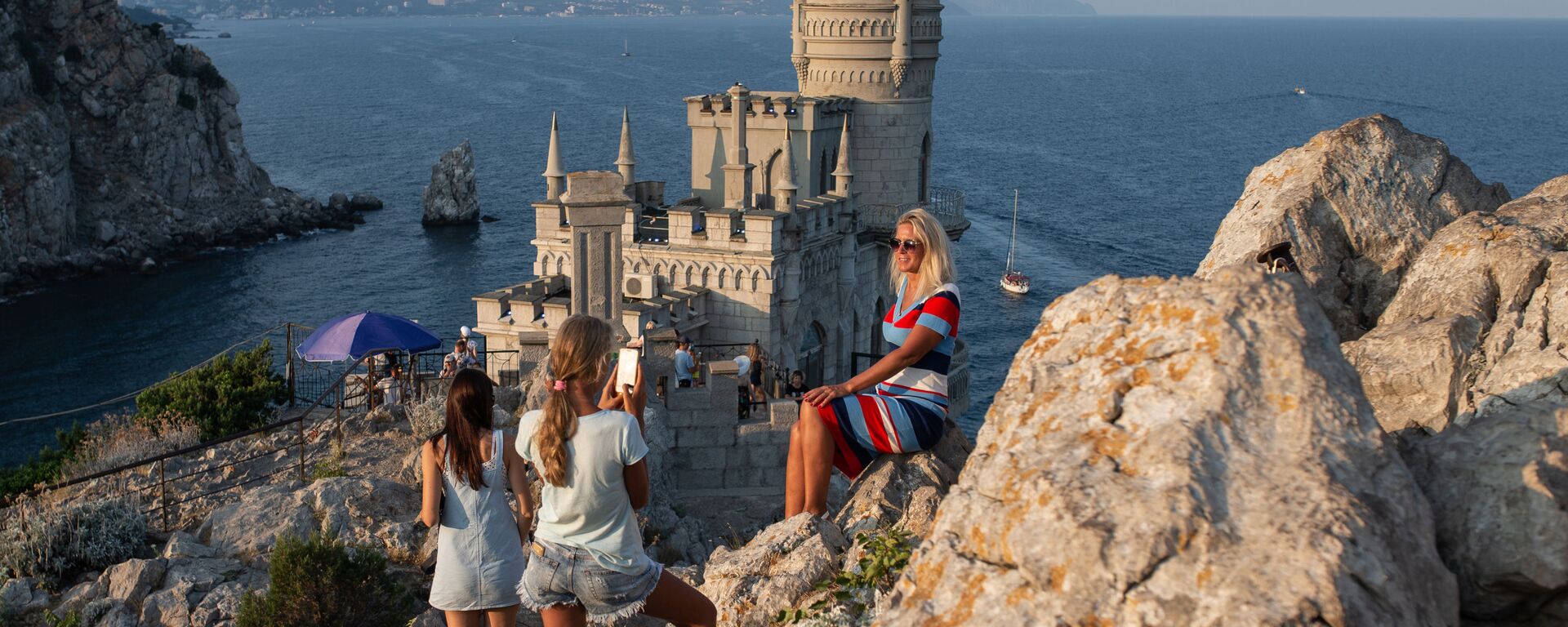 Отдыхающие фотографируются возле замка Ласточкино гнездо на береговой скале в поселке Гаспра в Крыму Отдыхающие фотографируются возле замка Ласточкино гнездо на береговой скале в поселке Гаспра в Крыму - Sputnik Mundo, 1920, 08.09.2021