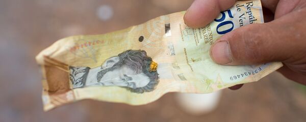 Una pepita de oro en un billete de bolívaro - Sputnik Mundo