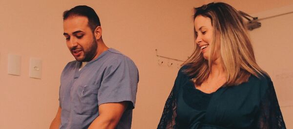 El obstetra brasileño Fernando Guedes da Cunha baila con su paciente, Camila Rocha, durante el trabajo de parto - Sputnik Mundo