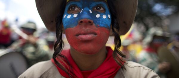 Una mujer miembro de la milicia bolivariana con el rostro pintado con los colores de la bandera de Venezuela - Sputnik Mundo