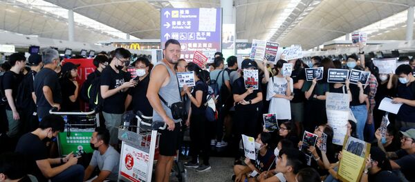 Un pasajero, esperando la embarcación durante las protestas en Hong Kong - Sputnik Mundo