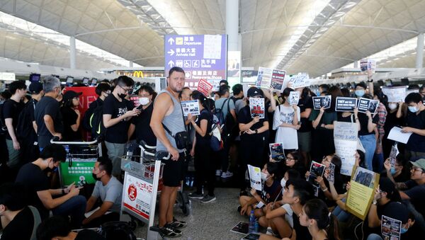 Un pasajero, esperando la embarcación durante las protestas en Hong Kong Un pasajero, esperando la embarcación durante las protestas en Hong Kong - Sputnik Mundo