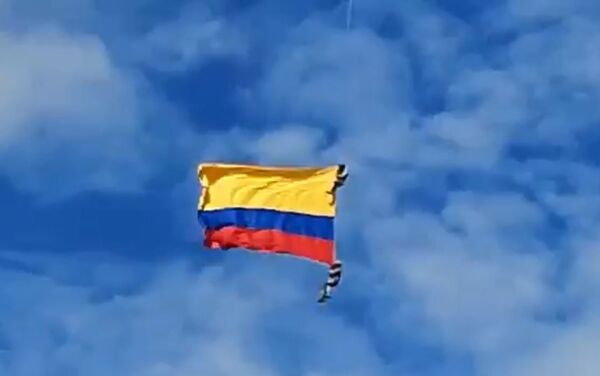 Dos soldados con la bandera de Colombia, colgados de un helicóptero, durante un espectáculo aéreo  - Sputnik Mundo