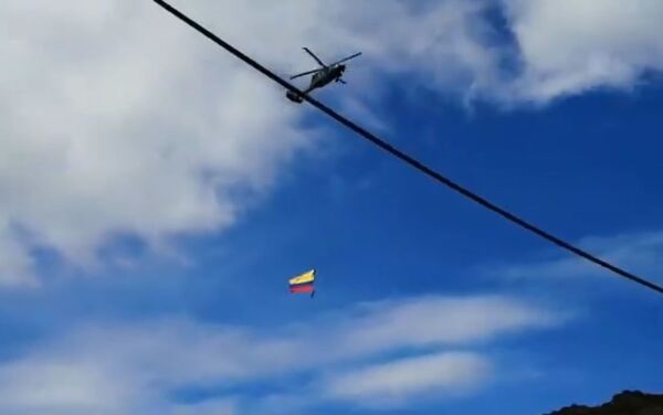 Dos soldados con la bandera de Colombia, colgados de un helicóptero, durante un espectáculo aéreo - Sputnik Mundo