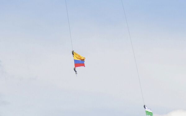 Dos soldados con la bandera de Colombia, colgados de un helicóptero, durante un espectáculo aéreo - Sputnik Mundo