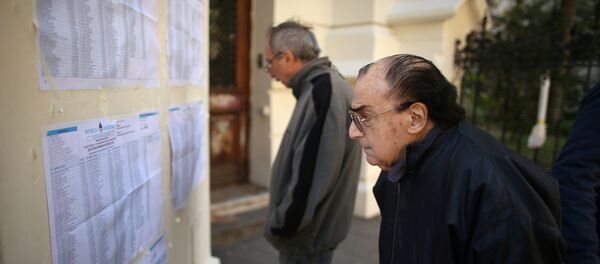 Un hombre observa las listas de votantes durante las elecciones primarias en Argentina Un hombre observa las listas de votantes durante las elecciones primarias en Argentina - Sputnik Mundo