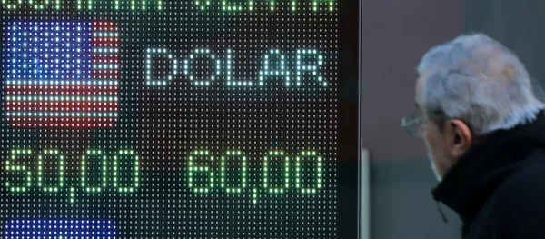 Un hombre mira la devaluación del peso argentino frente al dólar en una pantalla Un hombre mira la devaluación del peso argentino frente al dólar en una pantalla - Sputnik Mundo