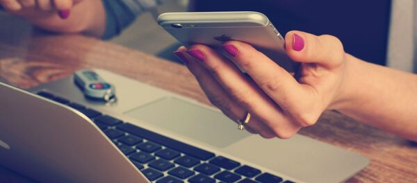 Una mujer usa un teléfono - Sputnik Mundo