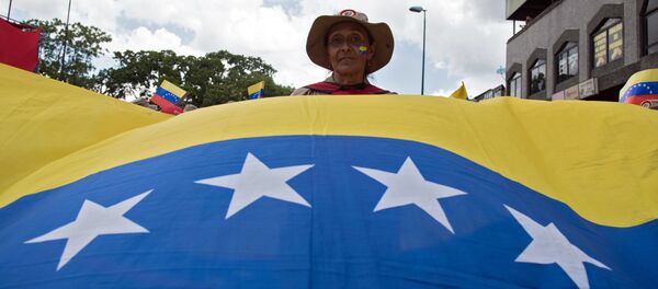 Una participante de una marcha en Caracas contra la política de sanciones de Estados Unidos - Sputnik Mundo