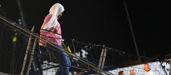 Una mujer bajando del Open Arms en Lampedusa Una mujer bajando del Open Arms en Lampedusa - Sputnik Mundo