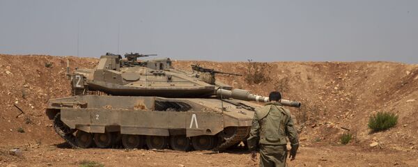 Un soldado israelí camina hacia el tanque en la frontera con Líbano Un soldado israelí camina hacia el tanque en la frontera con Líbano - Sputnik Mundo