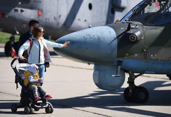 Пара с ребенком у военного вертолета Ка-52 Аллигатор на Международном авиационно-космическом салоне МАКС-2019 в подмосковном Жуковском - Sputnik Mundo