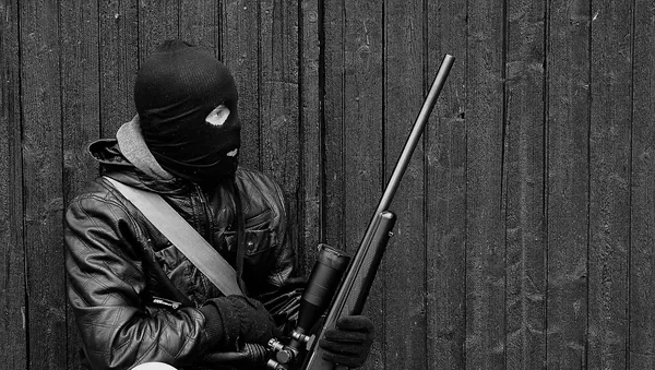 Un hombre en un pasamontañas con un arma - Sputnik Mundo