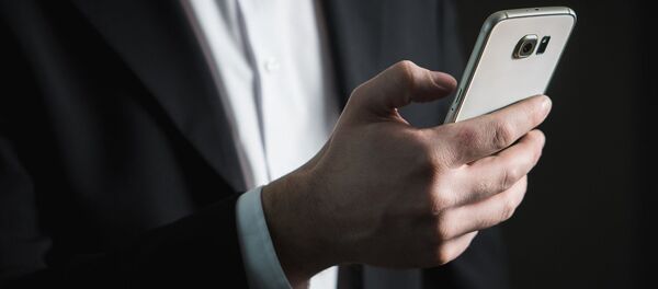 Un hombre con su teléfono - Sputnik Mundo