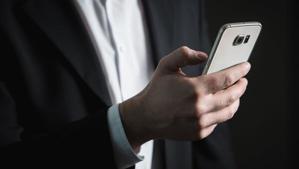 Un hombre con su teléfono - Sputnik Mundo