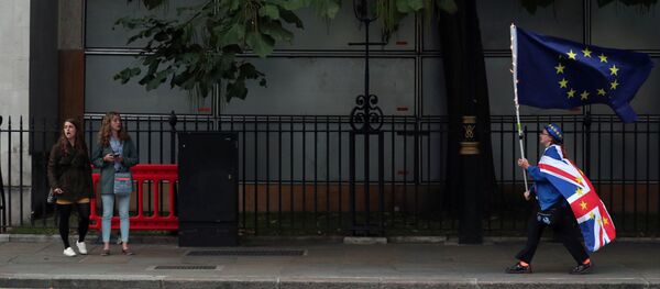 Un hombre con las banderas del Reino Unido y la UE - Sputnik Mundo