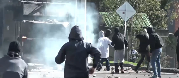 Piedras contra gases lacrimógenos: los estudiantes se enfrentan a la Policía en Bogotá - Sputnik Mundo