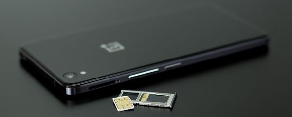 Un teléfono con una tarjeta sim, referencial - Sputnik Mundo