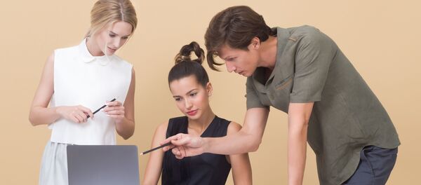 Varias personas trabajan con un laptop Varias personas trabajan con un laptop - Sputnik Mundo