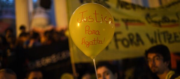 Una mujer sostiene un globo que dice Justicia para Agatha, durante la protesta contra la violencia policial en Rio de Janeiro - Sputnik Mundo