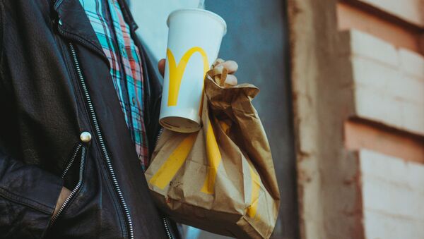 Una persona con alimentos de McDonald's - Sputnik Mundo