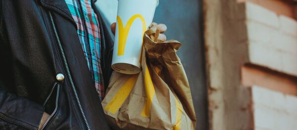 Una persona con alimentos de McDonald's - Sputnik Mundo