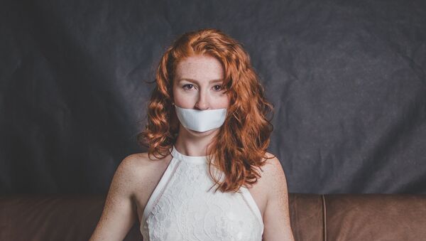 Una joven con una cinta en la boca Una joven con una cinta en la boca - Sputnik Mundo