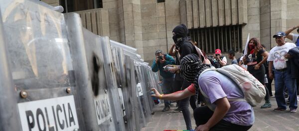 Un manifestante frente a los policías mexicanos durante la conmemoración del movimiento de 1968 - Sputnik Mundo