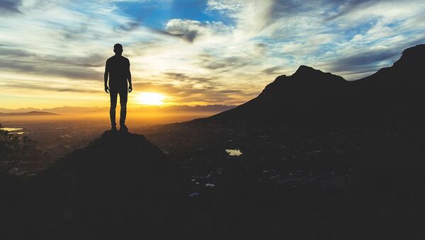 Un hombre observa la puesta del sol - Sputnik Mundo