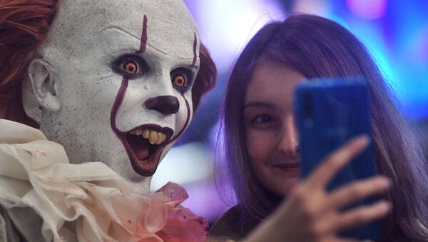 Una visitante de Comic Con se hace un selfí con un 'cosplayer' del payaso Pennywise - Sputnik Mundo