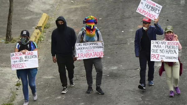 Jóvenes indígenas se manifiestan mientras el ataúd de su difunto líder, Inocencio Tucumbi, es llevado a la Casa de la Cultura en Quito, Ecuador