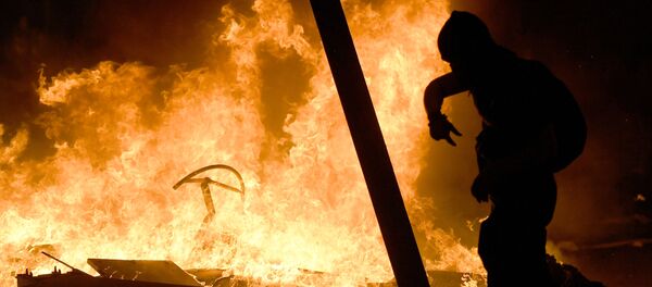 Un manifestante camina entre las barricadas en llamas durante una manifestación en Barcelona - Sputnik Mundo