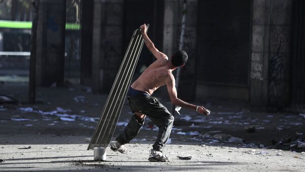 A demonstrator takes part in a protest against Chile's state economic model in Santiago, Chile - Sputnik Mundo