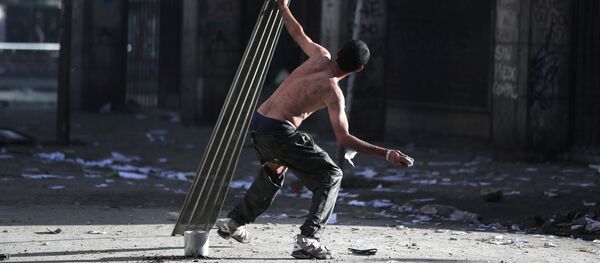 A demonstrator takes part in a protest against Chile's state economic model in Santiago, Chile - Sputnik Mundo
