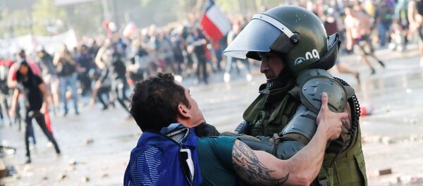 Manifestante se enfrenta a las fuerzas de seguridad de Santiago (Chile), el 24 de octubre de 2019 - Sputnik Mundo