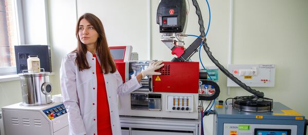 La empleada del Departamento de Biotecnología de la SFU, Anna Shumílova demuestra el dispositivo  - Sputnik Mundo