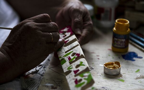 Patricia Chávez, pintando una de sus piezas confeccionadas - Sputnik Mundo