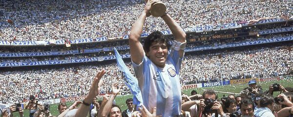Diego Maradona sosteniendo la Copa del Mundo en 1986, en el Estadio Azteca. - Sputnik Mundo