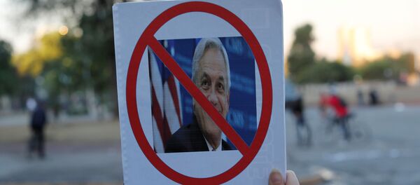 Un manifestante con la imagen del presidente chileno Sebastián Piñera - Sputnik Mundo