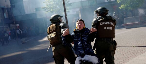 Carabineros de Chile atrapan a un manifestante durante una protesta Carabineros de Chile atrapan a un manifestante durante una protesta - Sputnik Mundo