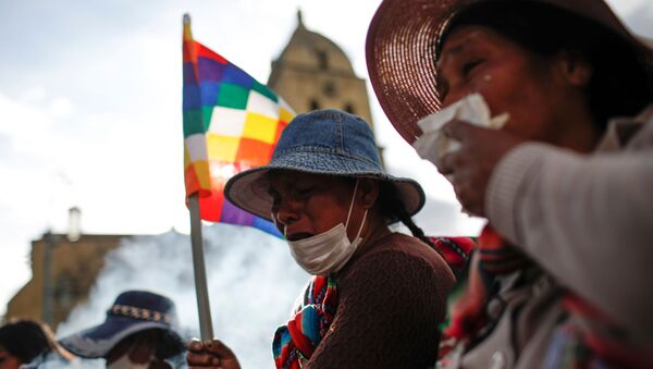 Manifestantes con banderas de Wiphala cubren sus bocas durante los enfrentamientos entre partidarios del expresidente boliviano, Evo Morales, y las fuerzas de seguridad en La Paz (Bolivia). Manifestantes con banderas de Wiphala cubren sus bocas durante los enfrentamientos entre partidarios del expresidente boliviano, Evo Morales, y las fuerzas de seguridad en La Paz (Bolivia). - Sputnik Mundo