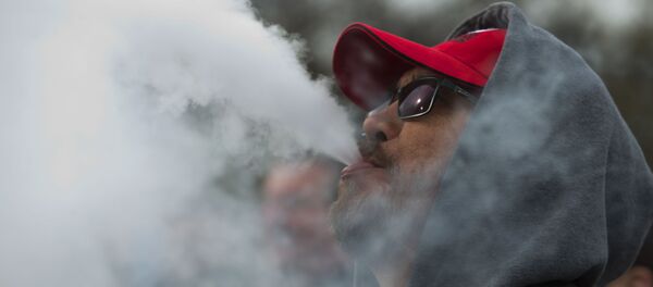 Un hombre fumando de un cigarrillo electrónico - Sputnik Mundo