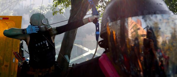 Un manifestante está lanzando una flecha en Hong Kong - Sputnik Mundo