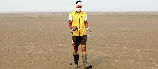 Un indio con pájaros moribundos en sus manos en el lago Sambhar  - Sputnik Mundo