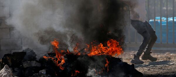 Un manifestante lanza la piedra durante protestas contra la demolición de los edificios palestinos - Sputnik Mundo