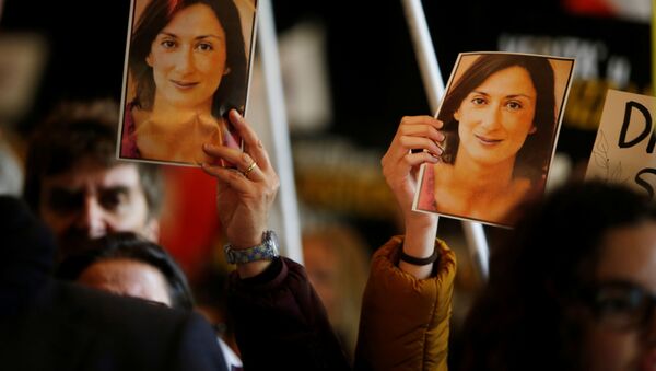 La gente sostiene las fotos de la periodista Daphne Caruana Galizia - Sputnik Mundo